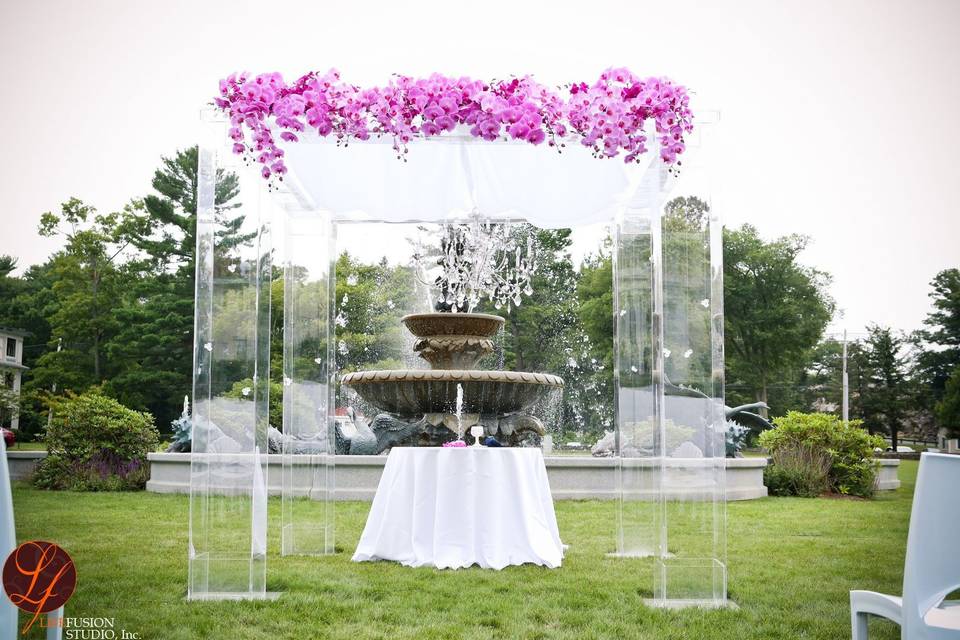 Clear acrylic chuppah with chandelier  and cascading phalaenopsis orchids