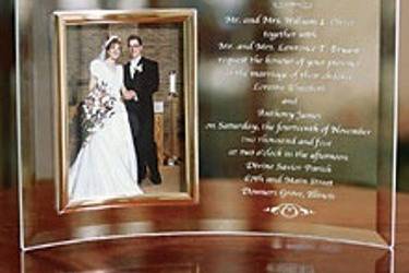 Make today's gift tomorrow's heirloom with our beveled glass picture frame that encases an 8 x 10 photograph. It is very gracefully bent and capable of standing on it's own as shown . We will engrave the text of your wedding invitation , poem, or any special dedication on this lovely crystal frame (14 line maximum).