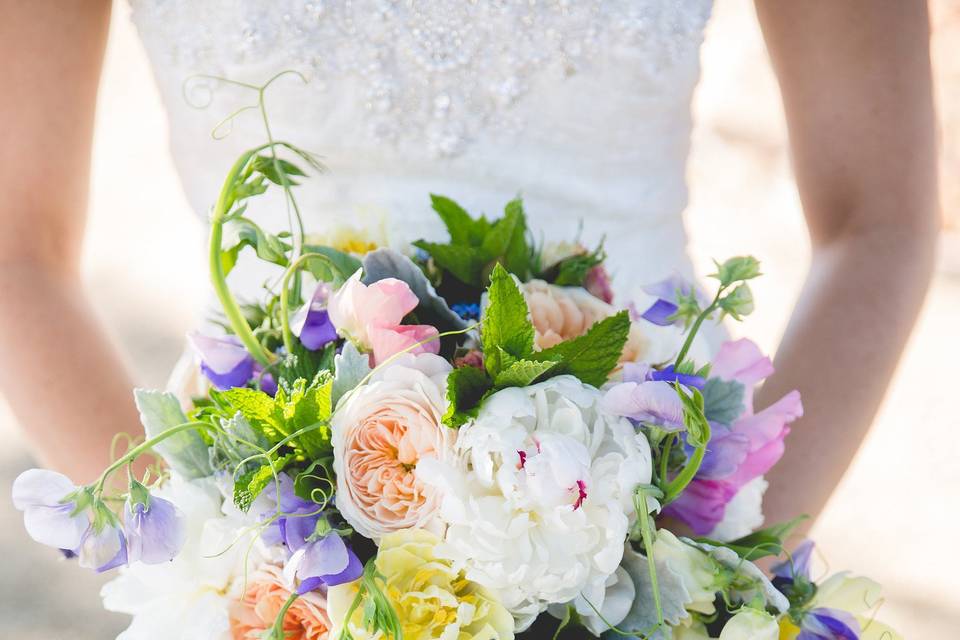 Romantic garden bouquet: clematis and passion vine, peonies, garden roses, sweet peas, and tulips.