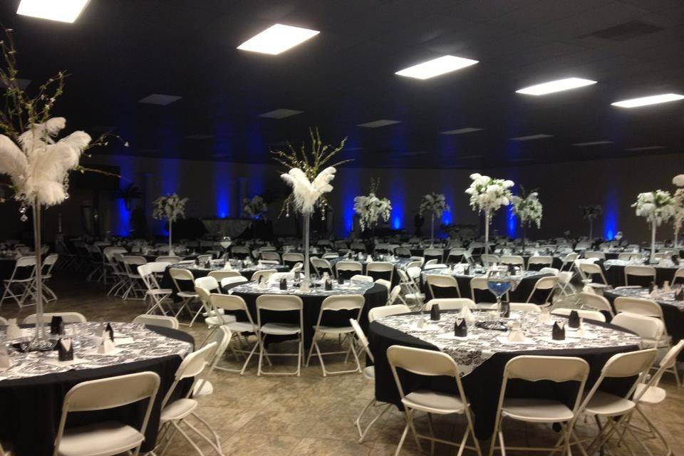 Main reception area. Features black and white design with centerpieces and blue uplights