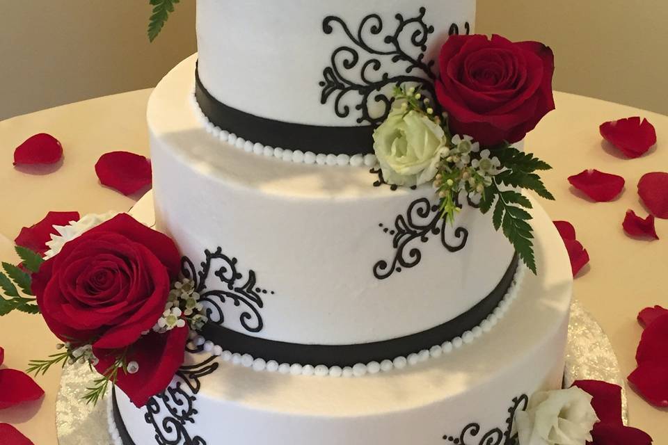 Fresh roses adorn this flawless buttercream beauty!