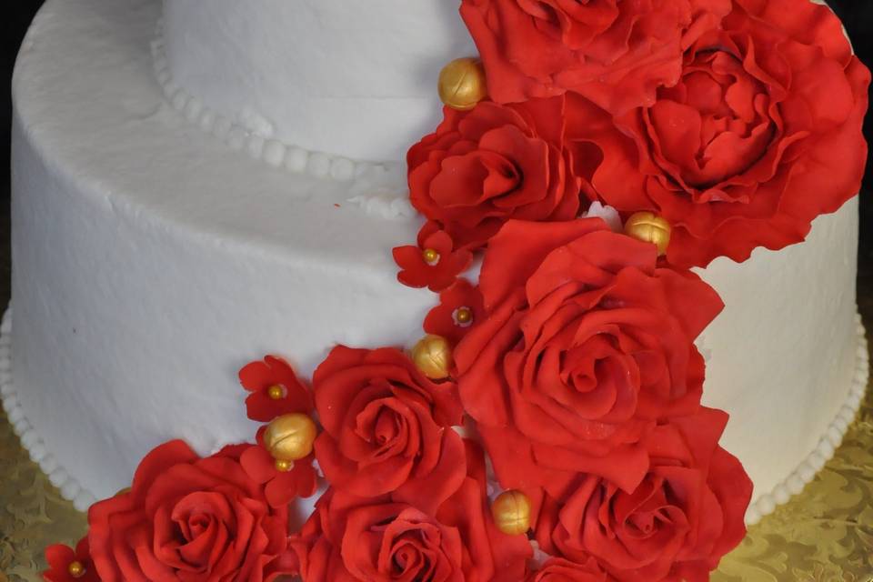 Bright red handmade sugar roses and peonies make this simple buttercream cake striking!