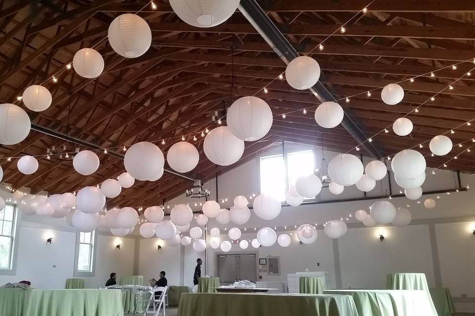 String lighting with white paper lanterns inside the Harvest Barn at Meadow View at Cranwell Resort in Lenox, Mass.