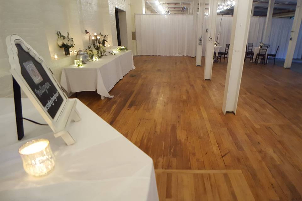 White pipe and drape divide the North Room of the Stationery Factory to help with the flow of guests at the cocktail hour of this wedding.