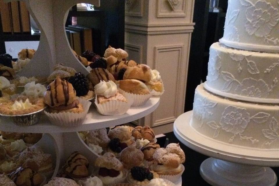 Mini pastry tower with chocolate eclairs, cream puffs, fruit tarts, and more