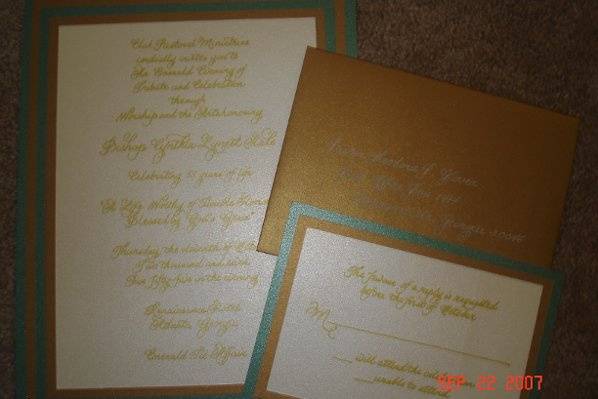 Handwritten invitations in gold ink on brushed metallic paper with matching envelopes.