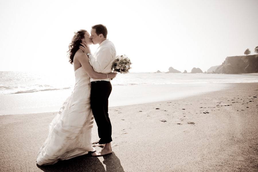 A romantic moment after the wedding by the Pacific Ocean, on the Mendocino Coast of California.