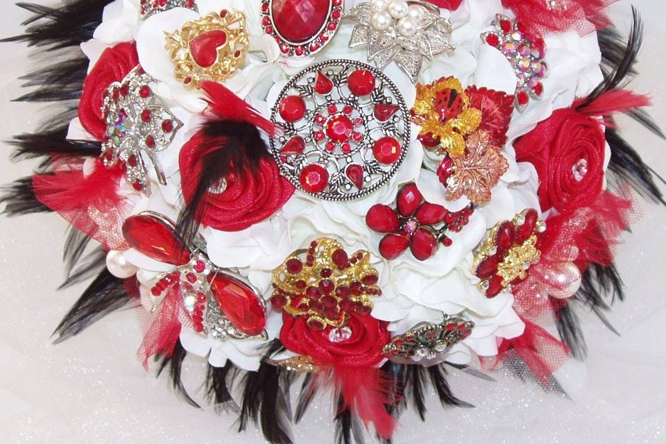 Glamourous brooch jeweled bouquet studded with rhinestone and crystal brooches, with white silk hydrangea, red satin ribbon roses and black feathers. Shown here in white, red and black but available in other colors