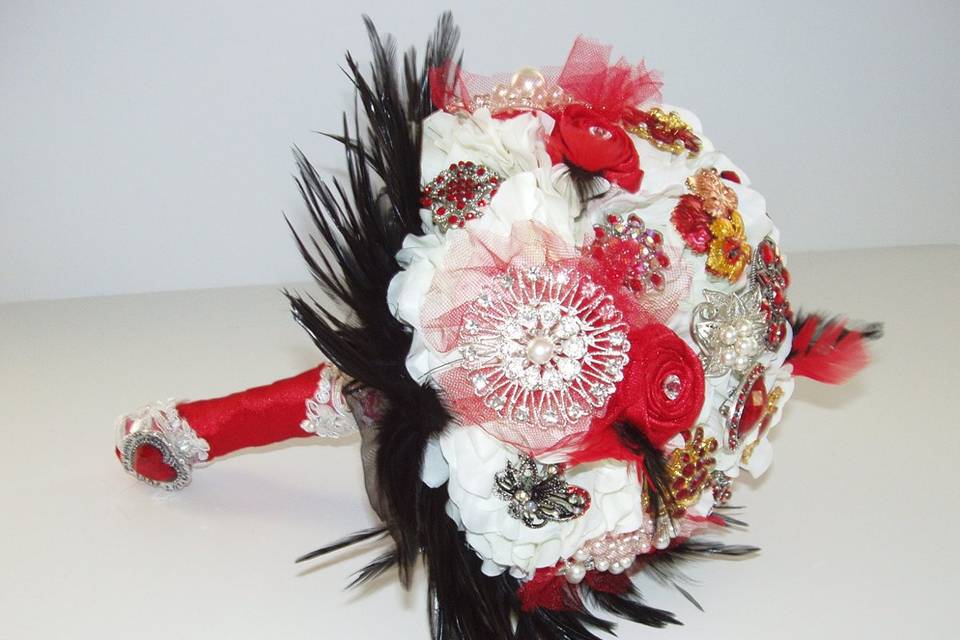 Glamourous brooch jeweled bouquet studded with rhinestone and crystal brooches, with white silk hydrangea, red satin ribbon roses and black feathers. Shown here in white, red and black but available in other colors