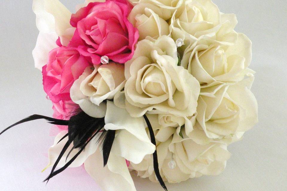 Lovely and romantic bouquet created with TRUE TOUCH silk roses and calla lilies, in ivory and hot pink, with black feather accents.
The handle is wrapped in damask ribbon with a hot pink overlay. This bouquet is available in other colors.