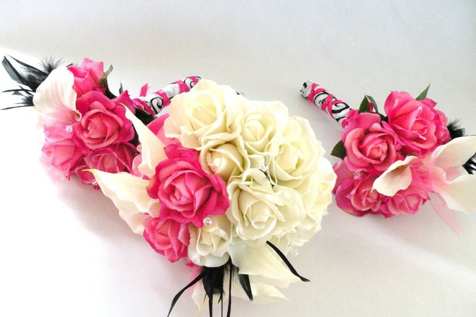 Lovely and romantic bouquet created with TRUE TOUCH silk roses and calla lilies, in ivory and hot pink, with black feather accents.
The handle is wrapped in damask ribbon with a hot pink overlay. This bouquet is available in other colors.