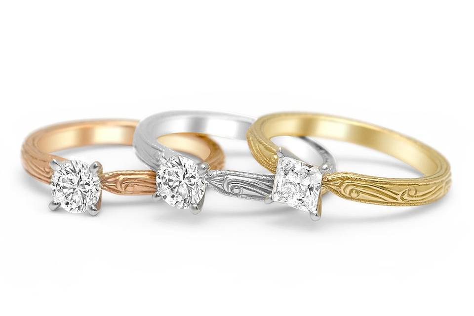 Our beautiful vintage inspired solitaires are engraved and come in a variety of colors and shapes. See here: Rose gold with a round diamond, platinum with a round diamond, and yellow gold with a princess cut diamond.