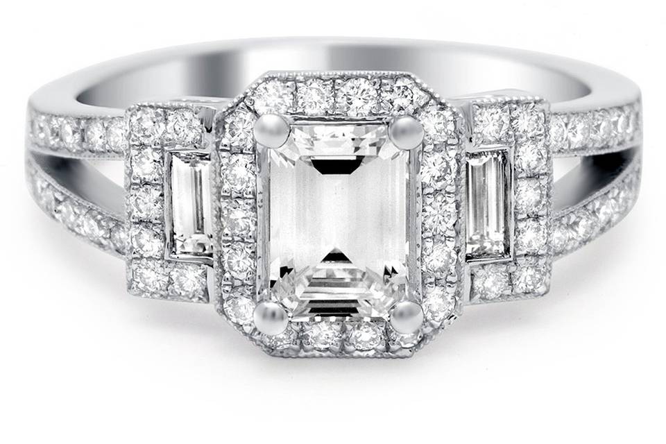 Stunning emerald cut halo diamond ring has a diamond encrusted split shank and side baguettes.