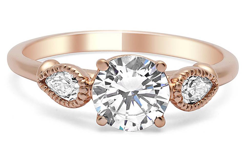 Rose gold 3-stone ring has 2 pear shaped diamonds trimmed in milgrain.