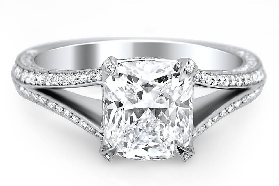 Stunning cushion cut diamond in claw prong setting with diamonds covering split shank.