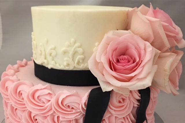 Pink rose themed cake with black ribbon