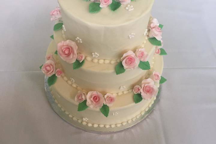 Simple three tier wedding cake with light pink rose decorations