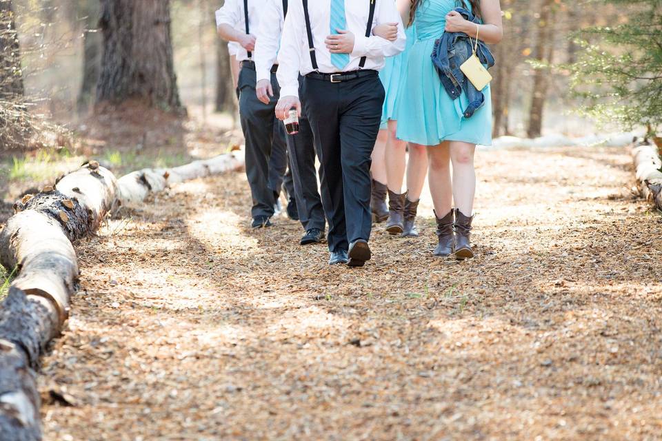 The bridal party making their entrance to the Forest Pavilion down the log-lined path.