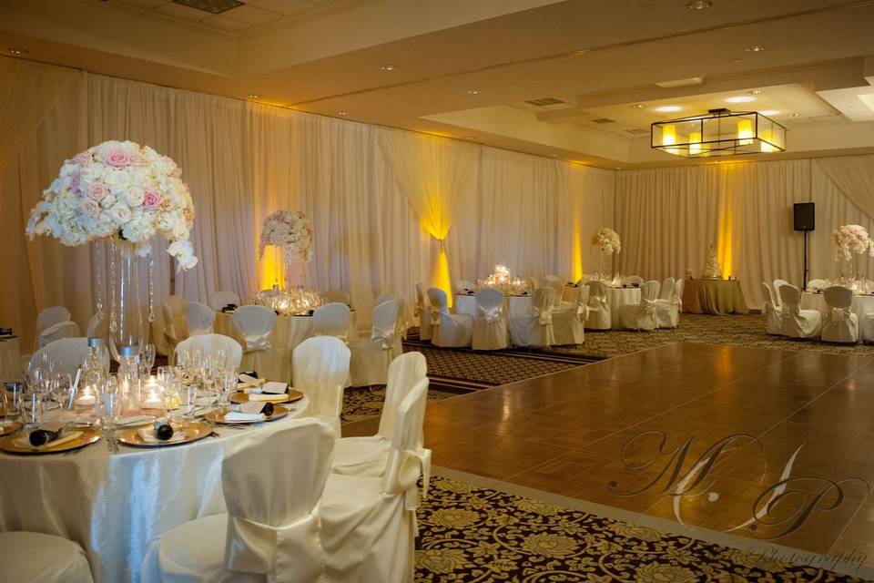 White poly wall draping with ivory hourglass and amber uplighting
