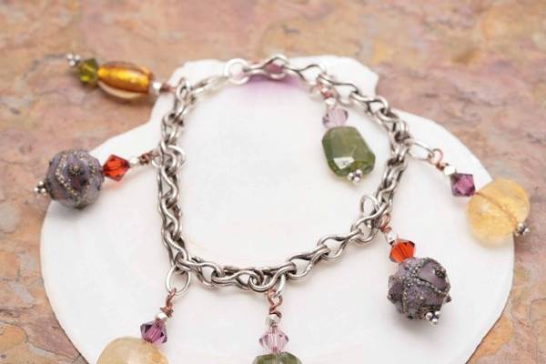 7-1/2 Inch bracelet of Faceted Citrine and Grossular Garnet nuggets, Swarovski Crystals, Lampwork Beads, and Cloisonne Beads on hand-twisted copper and silver wires. Oxidized Sterling chain and Lobster clasp.