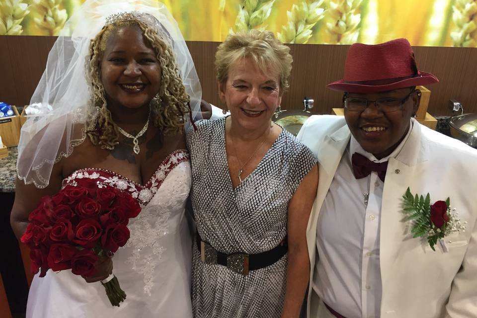 Couple posing with officiant