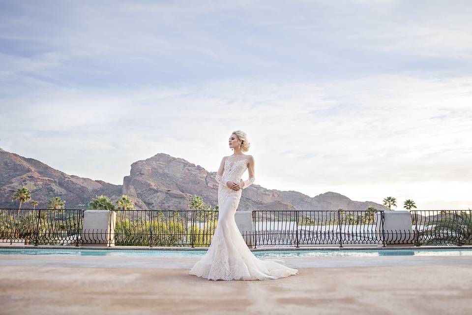 Bride in an elegant sleeved dress by the poolside