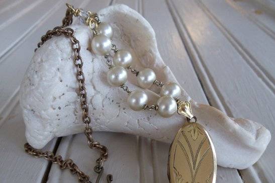 I really love the classic simplicity of a strand of pearls, so I incorporated that element into this piece. The centerpiece is a lovely antique locket (I've left the sweet photos that came in it intact). I've added a small strand of vintage plump pearl beads and accented them with two small antique crystal beads. The chain is brass and measures 18 1/2