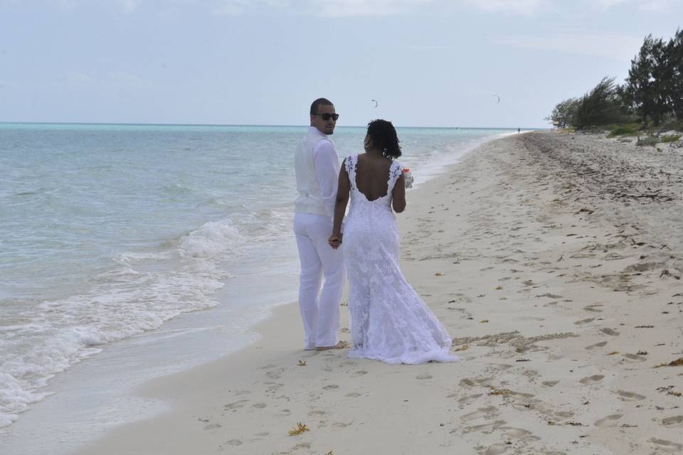 Newlyweds stroll down the beach