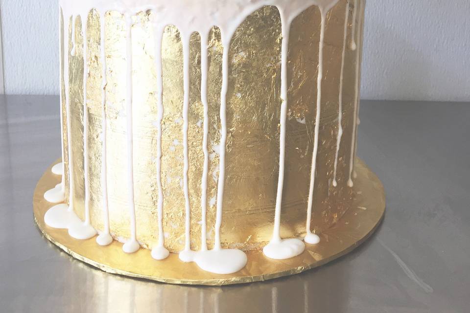 Golden cake dripping in white