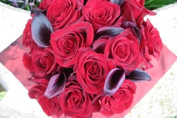 Beautiful round red rose and eggplant mini calla lily bouquet to show your passion.