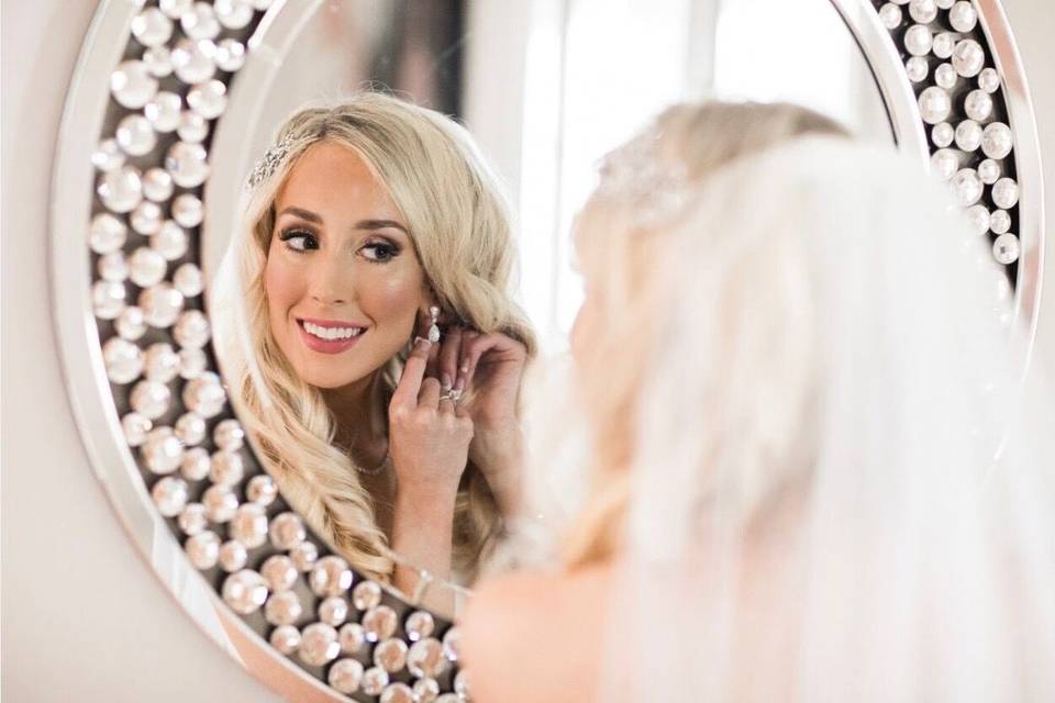 Bride putting on earrings