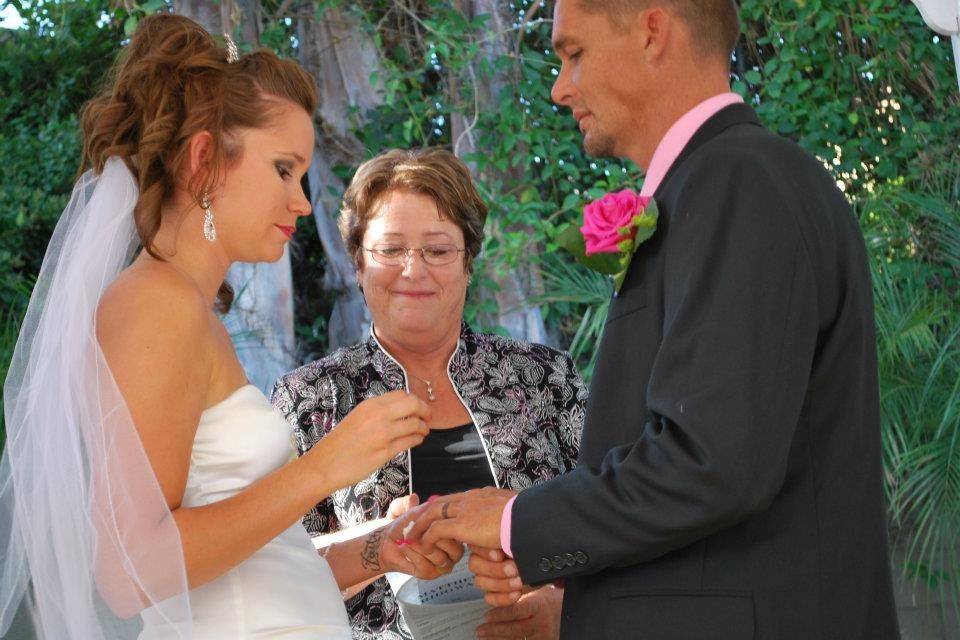 Bride putting a ring on her groom