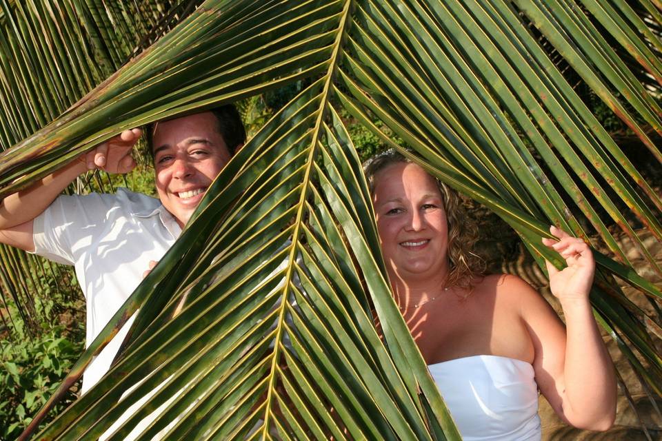 couple peeking through palms