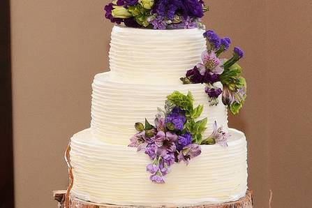 Three tier wedding cake with purple flowers