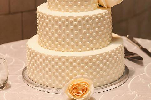 Three tier wedding cake with purple flowers