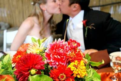 centerpiece in front of the bride and groom kissing