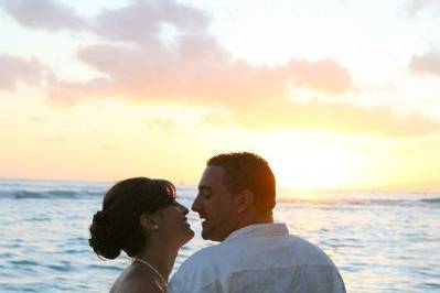 newlyweds viewing the sunset after a hawaii beach wedding