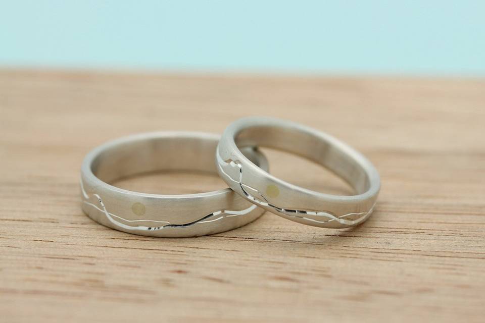 Recycled sterling silver bands with custom engraved mountain design.