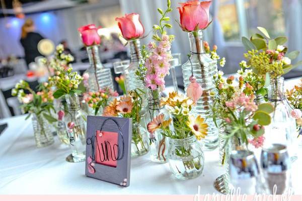 Design by Garden Gate Florals.  Picture by DanielleNicholPhotography.  Retro/Vintage bottles filled to overflowing with loose flowers.  Table Number Nine!!