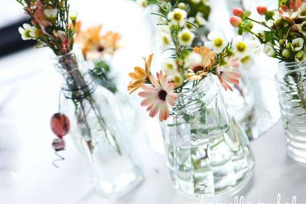 Lots of bottles with loose flowers adorn this Head table of the Bride and Groom and their wedding party.  TheNotWedding-Orlando Event-March 15,2012.  Design by Garden Gate Florals.  Photo by DanielleNichol Photography.