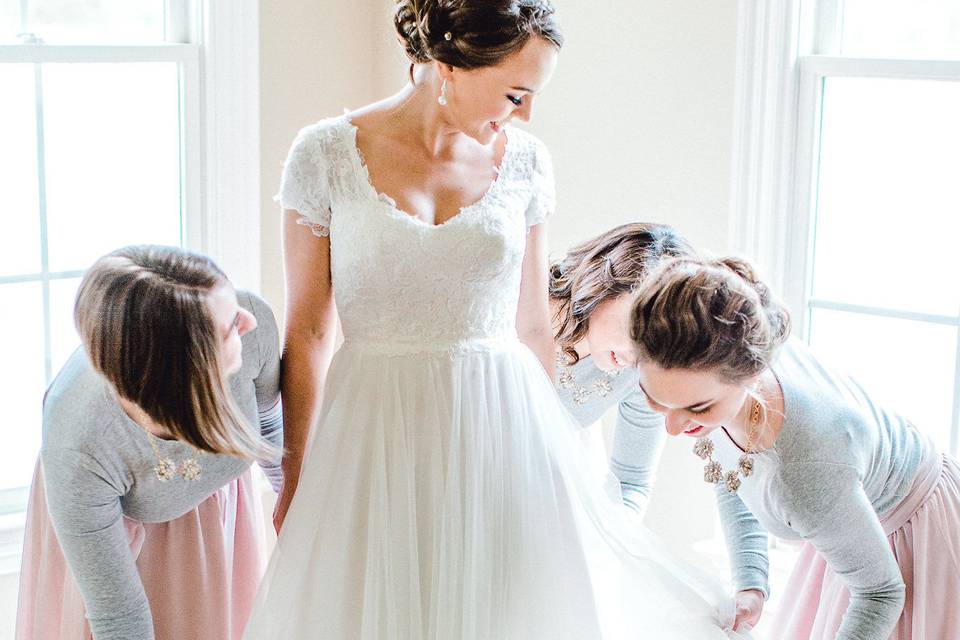 Bridesmaids helping bride