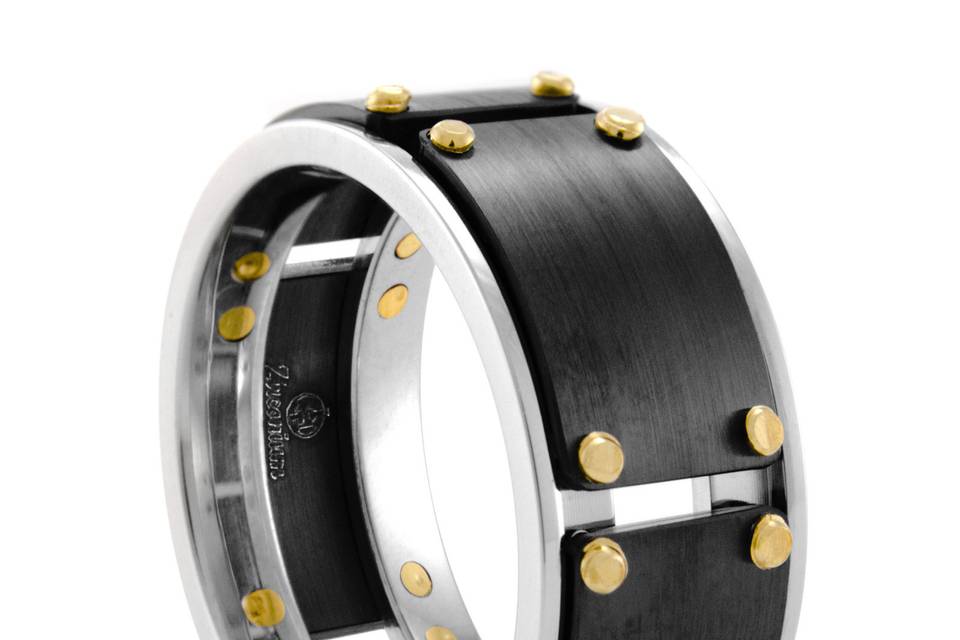 This industrial themed ring measures a substantial 10mm wide and features black Zirconium plates that encircle the ring. The edges are of high polished Cobalt. Notice how the 18K yellow gold rivets tie it all together.