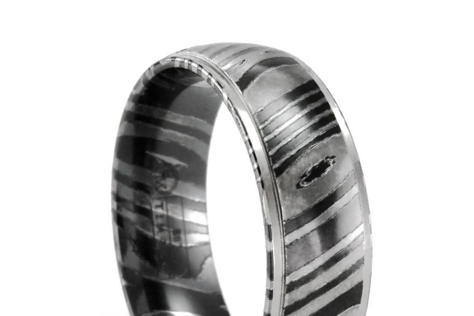 This TIMOKU ring is 7mm wide, has a slightly rounded profile and dropped edges that are high polished. Ring is comfort fit as well. One of our more popular wedding bands for guys. Most sizes are not in stock and are custom made for you when you order.