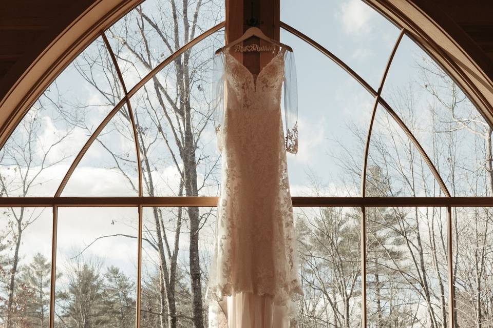 Brides dress in barn window