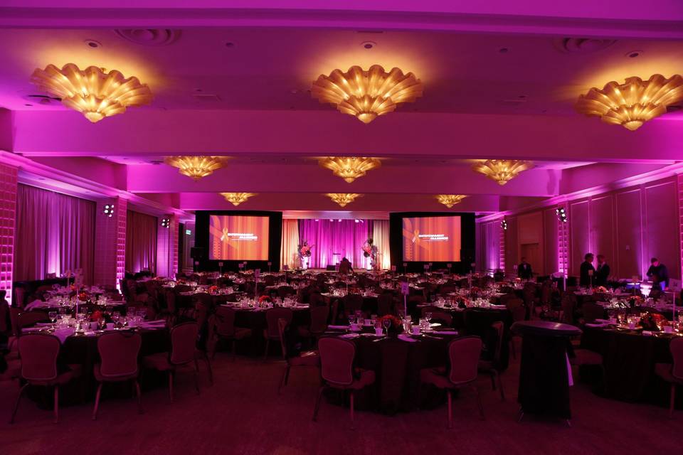 Large hotel ballroom wedding reception with awesome pink uplighting, video projection system, and DJ sound system.