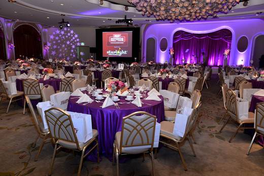 Chic purple lighting and linens with custom video projection in a hotel ballroom.