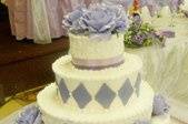 Buttercream tier cake with six individual cakes.  Accent with purple fondant diamonds and satin ribbon.