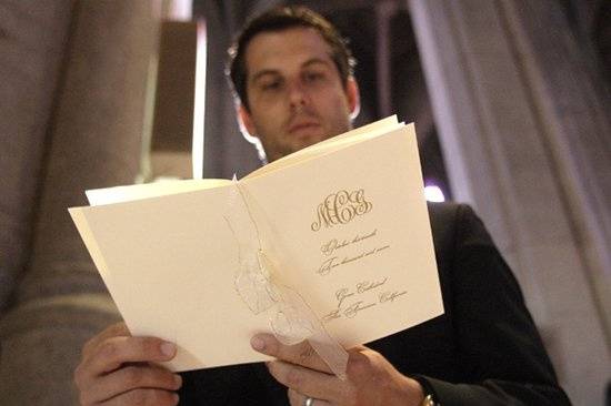 A groomsman takes a moment to read the program at Grace Cathedral in San Francisco.