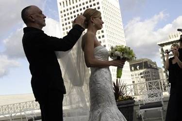 Stylist Jim Avila places the veil on the bride at the Ritz Carlton Hotel in San Francisco.