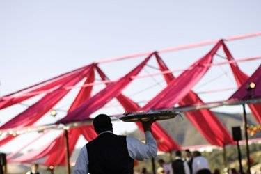 A member of the wait staff brings entrees to the tent at Boot Hill located on the property of Kunde Estates Winery.